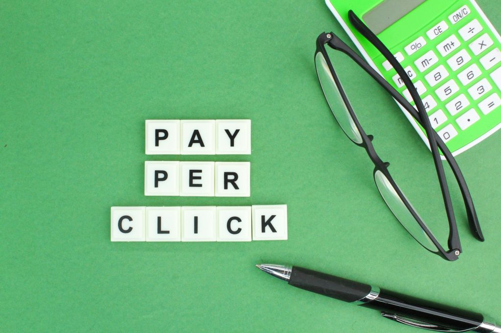 pen, glasses and a calculator with the word pay per click.